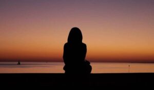 Silhouette of person watching sunset over the ocean